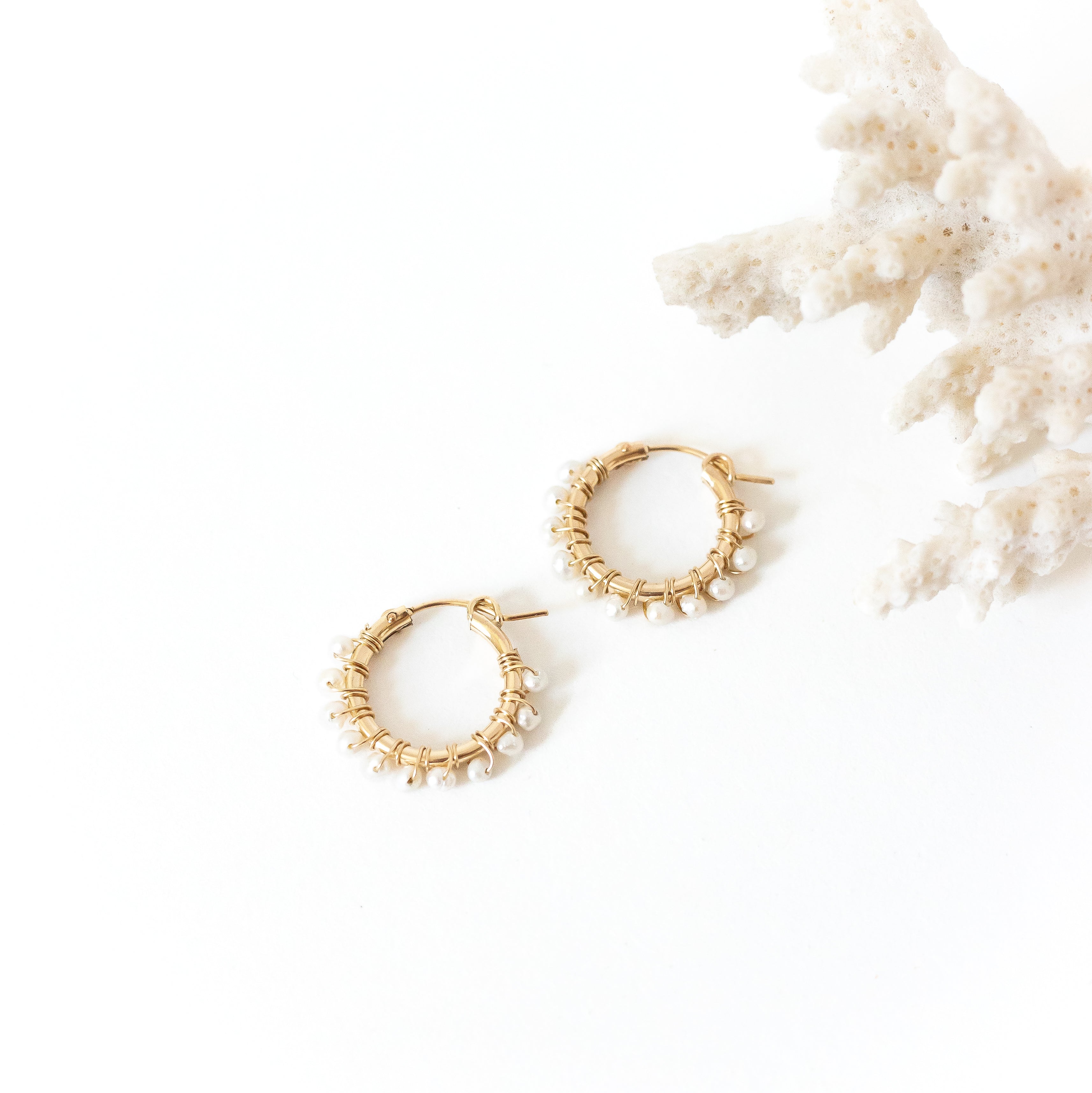 Gold hoops with pearls wire wrapped around it. 