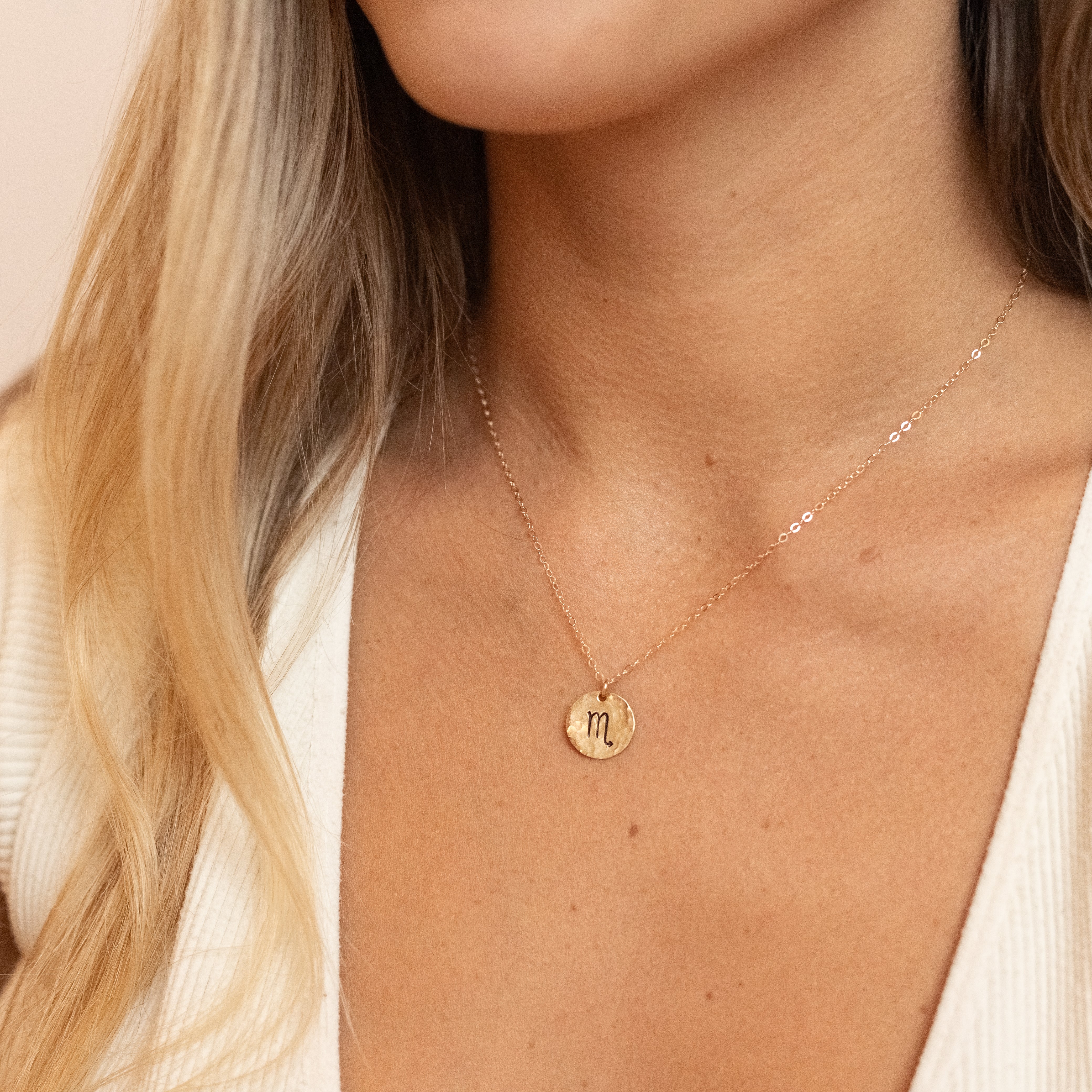 gold filled zodiac charm necklaces. Shown on a woman's neck. 