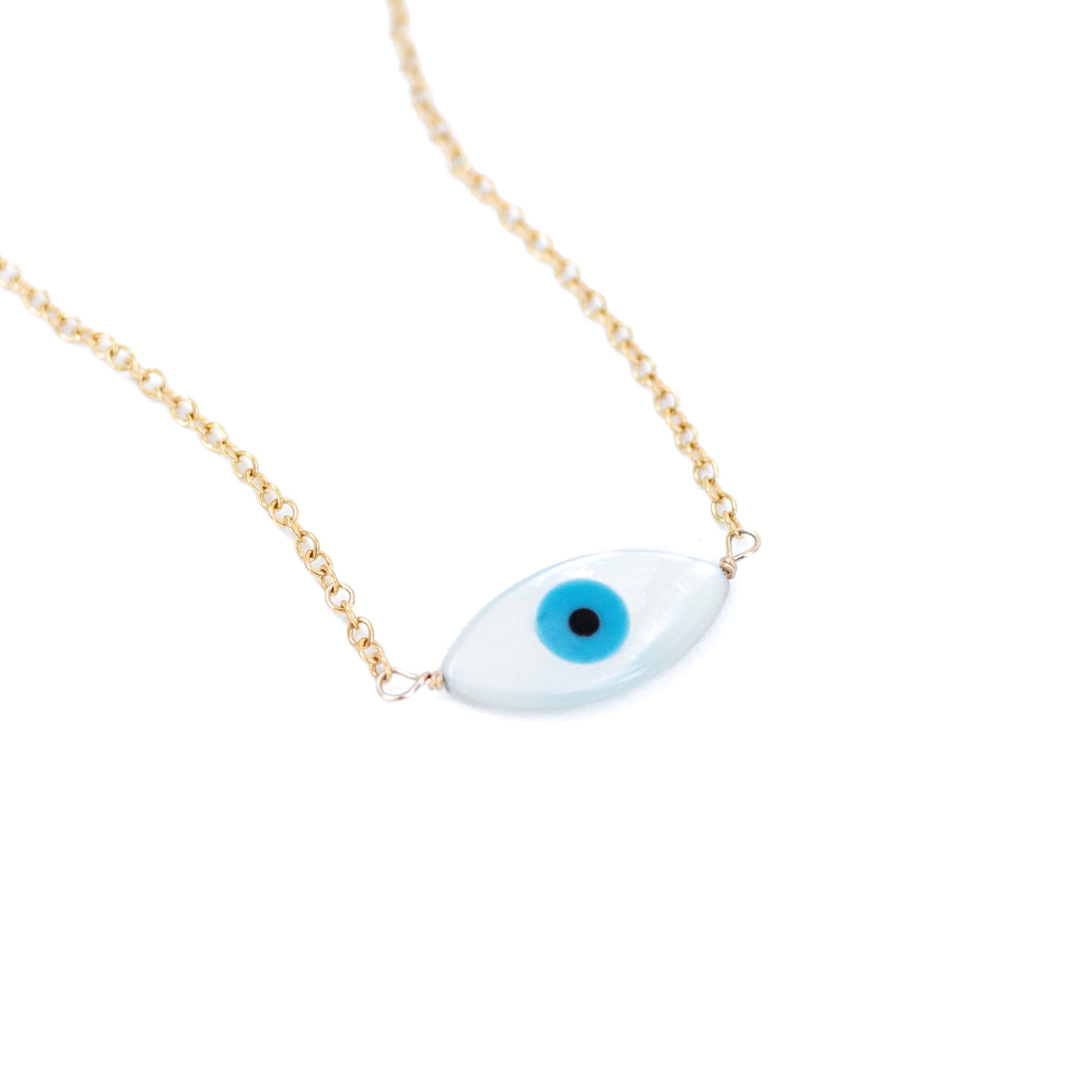 Mother of pearl evil eye charm wire wrapped with gold wire to delicate gold chain.