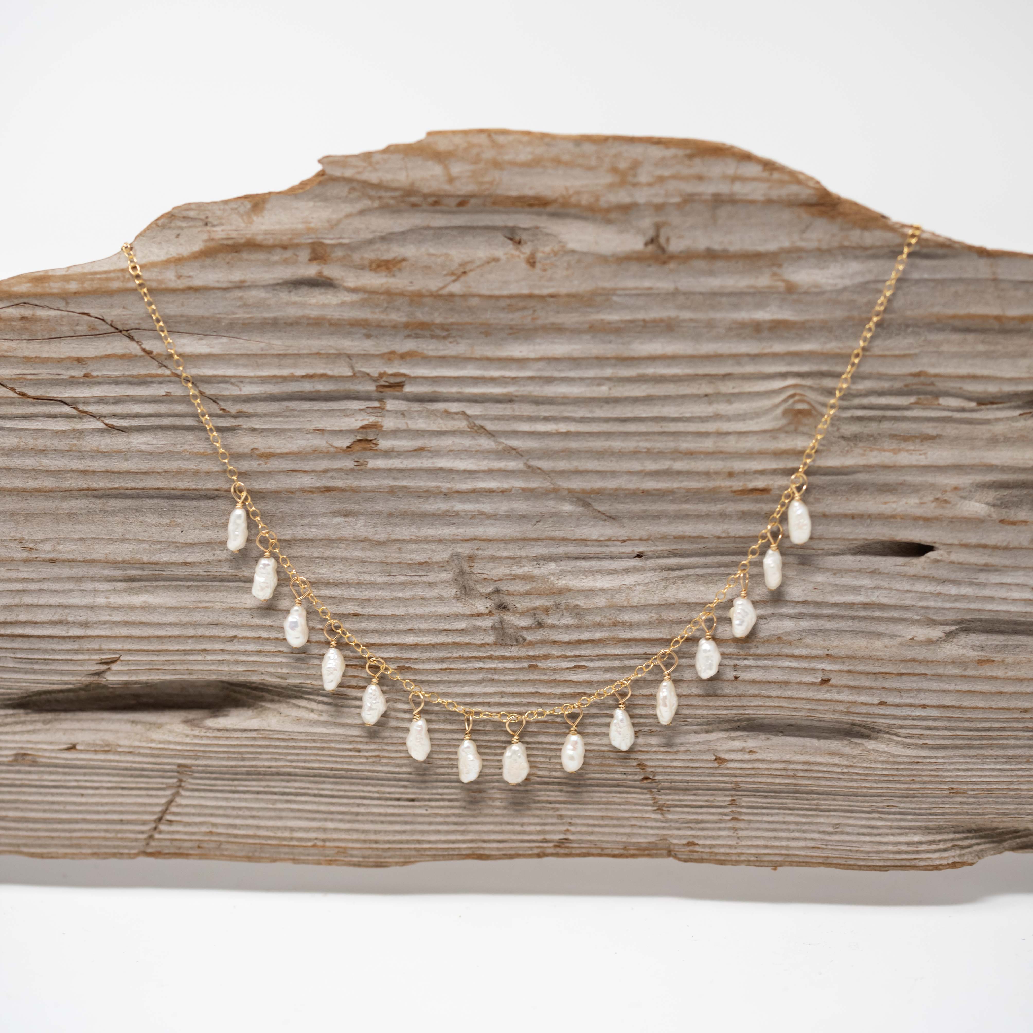 Gold chain with 15 pea sized freshwater pearls attached to it.