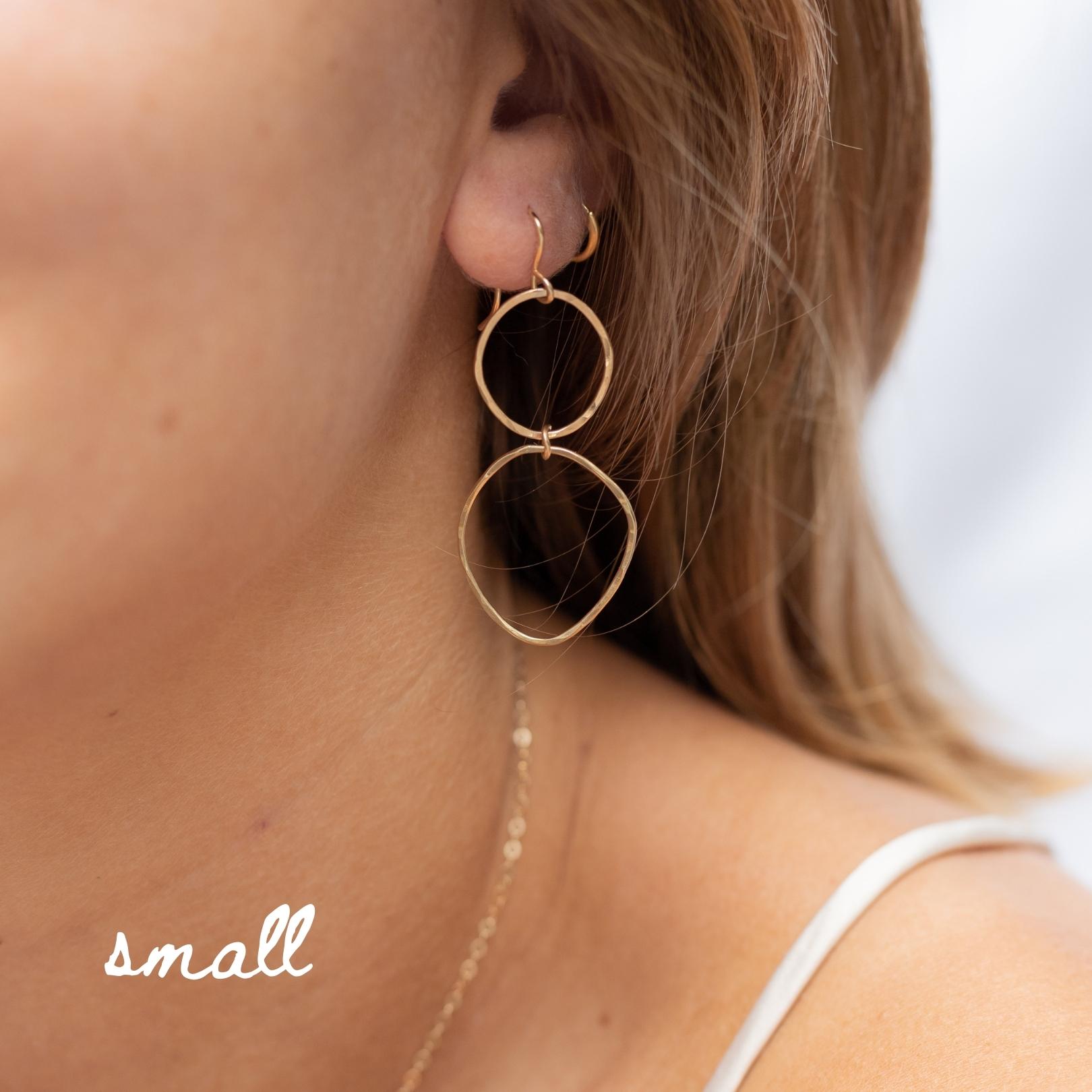 Hammered gold filled double hoop earrings. Three different sizes. Small: about 1.5 inches. Shown in a woman's ear. 