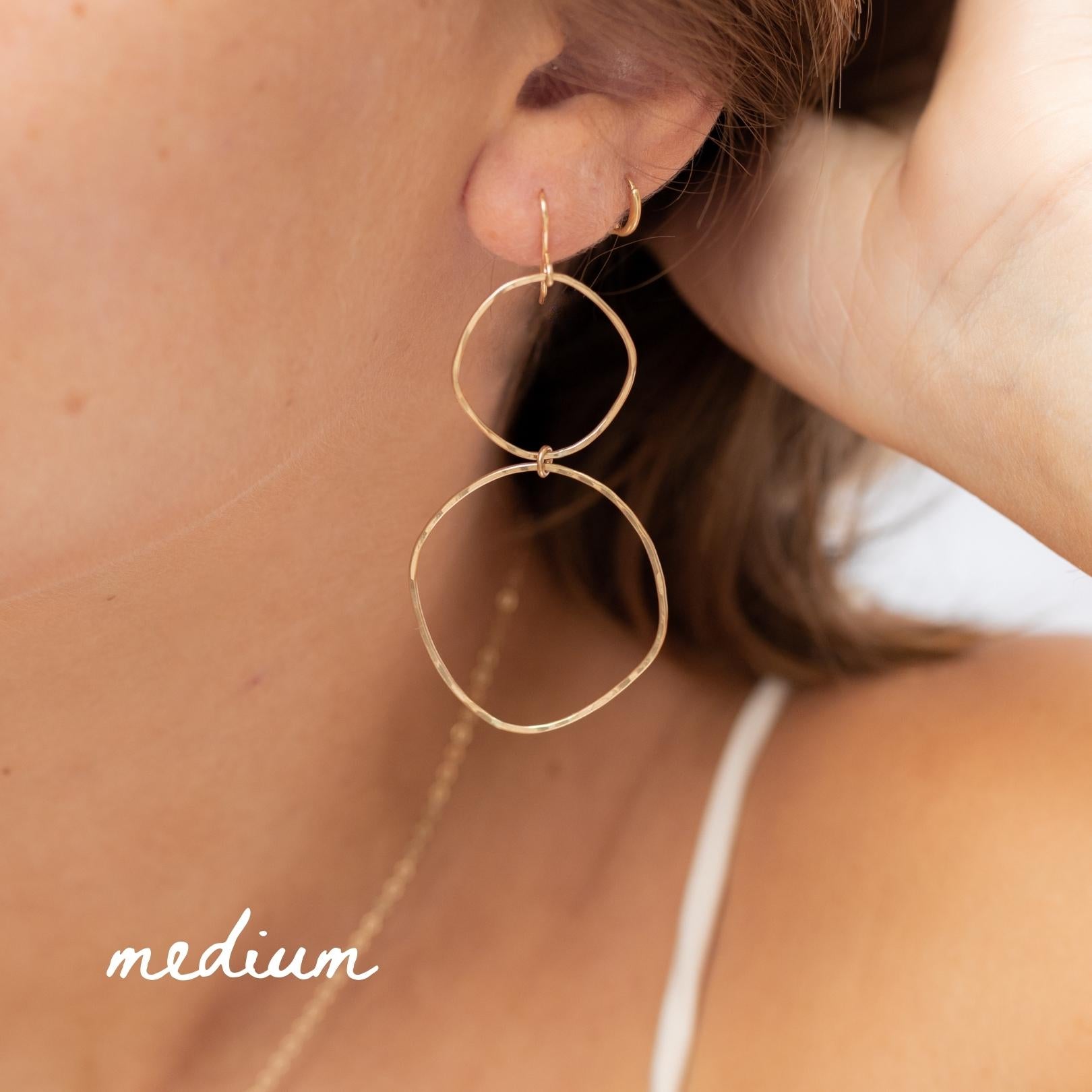Hammered gold filled double hoop earrings. Three different sizes. medium: about 2.5 inches. Shown in a woman's ear.