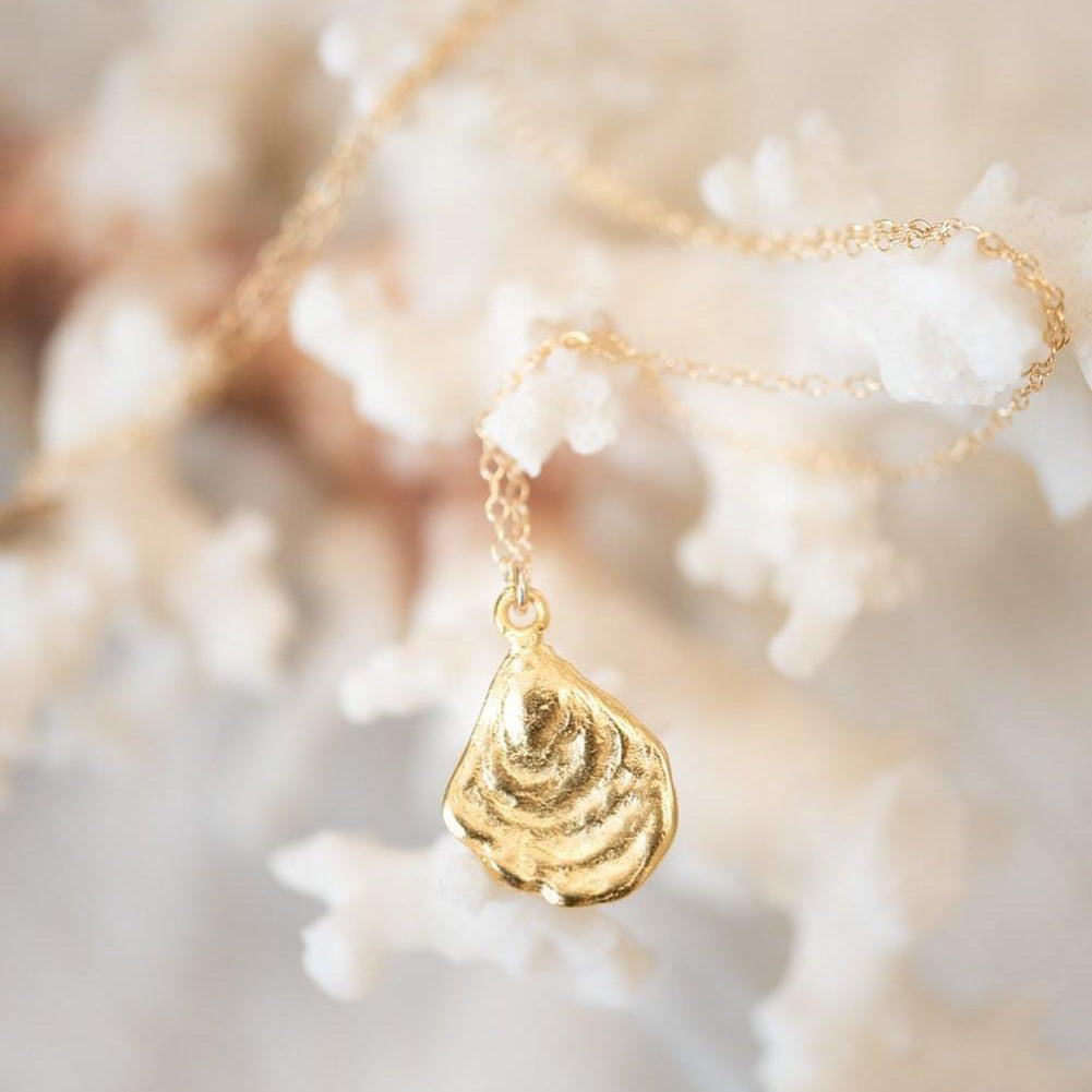 Small gold dipped oyster shell charm attached to a 14 carrot gold chain.