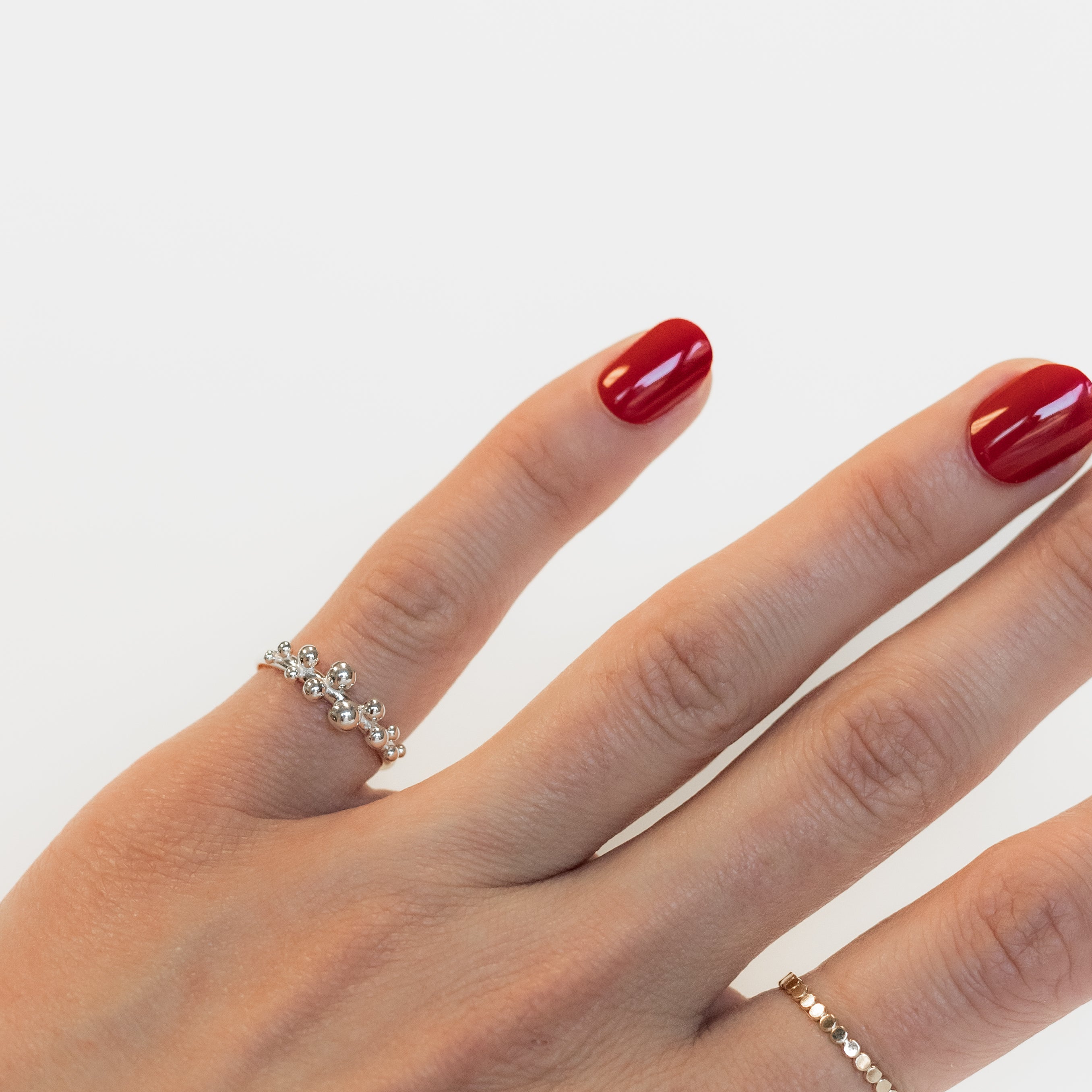 Sterling silver dew drop ring shown on a woman's hand. 