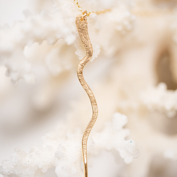 Hand forged gold filled snake necklace attached to a gold chain.