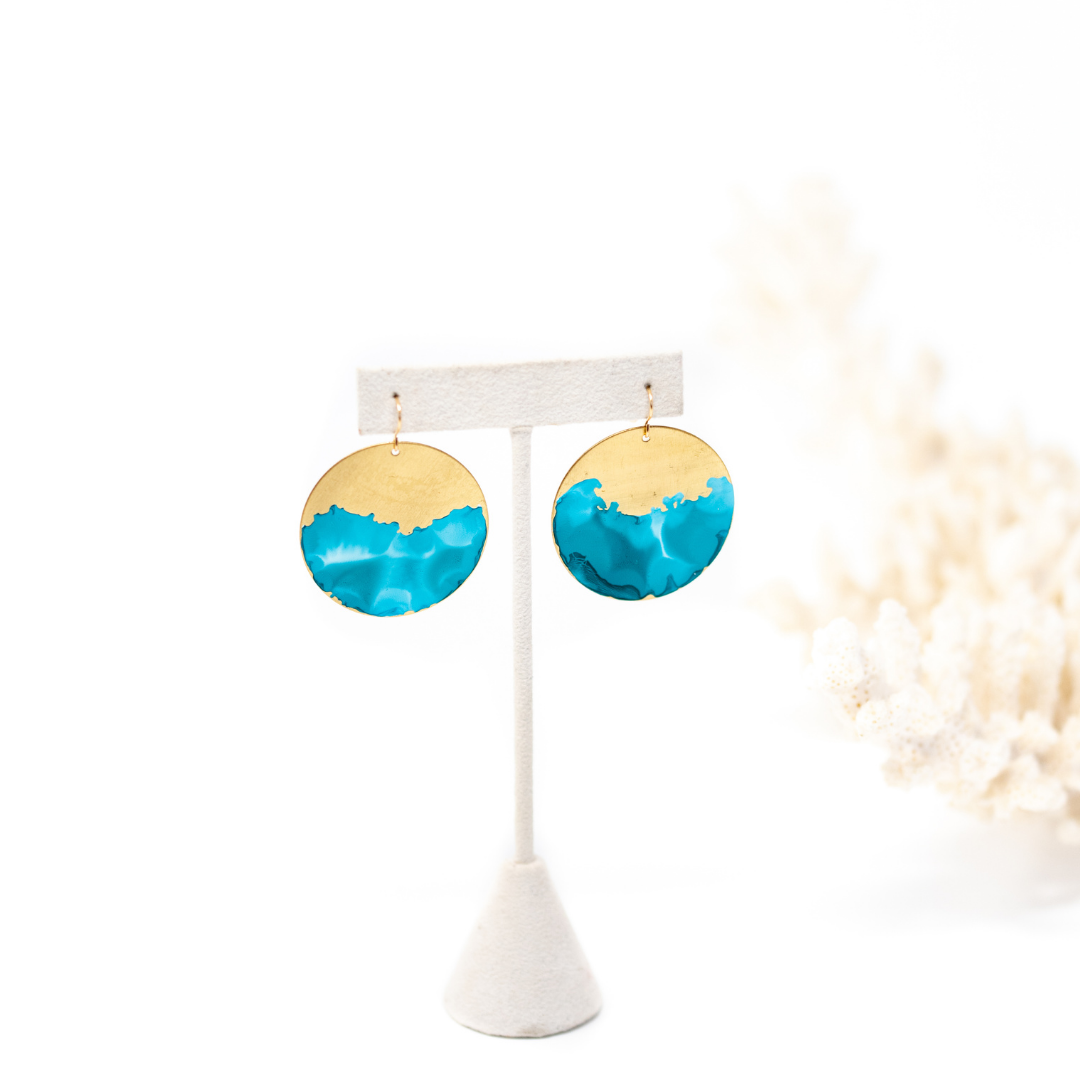 Brass circle earrings hand painted to have organic blue wave looking design on the bottom half.