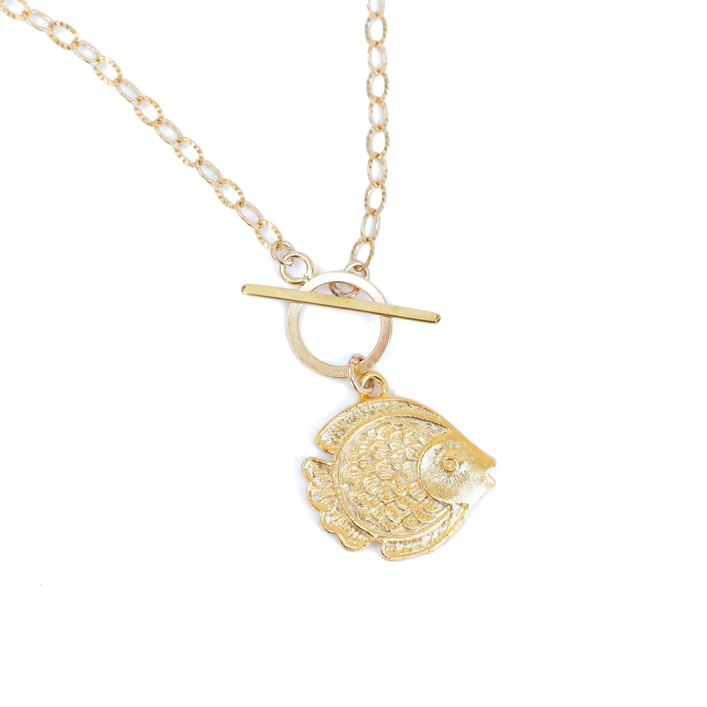 A gold vermeil angel fish charm on a large gold-filled toggle clasp and textured gold-filled chain on white background