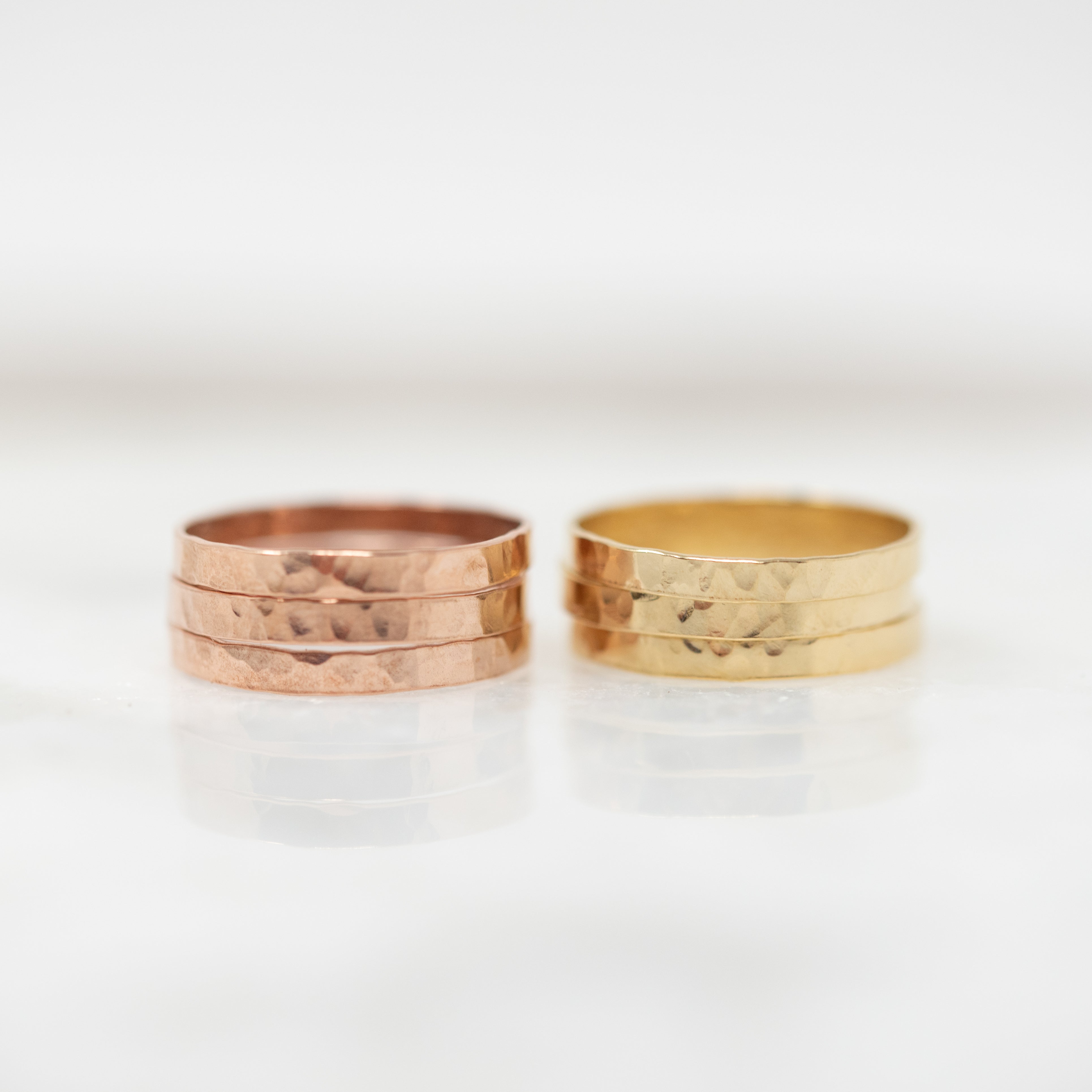 Rose gold filled hammered ring stack next to gold filled hammered ring stack. 
