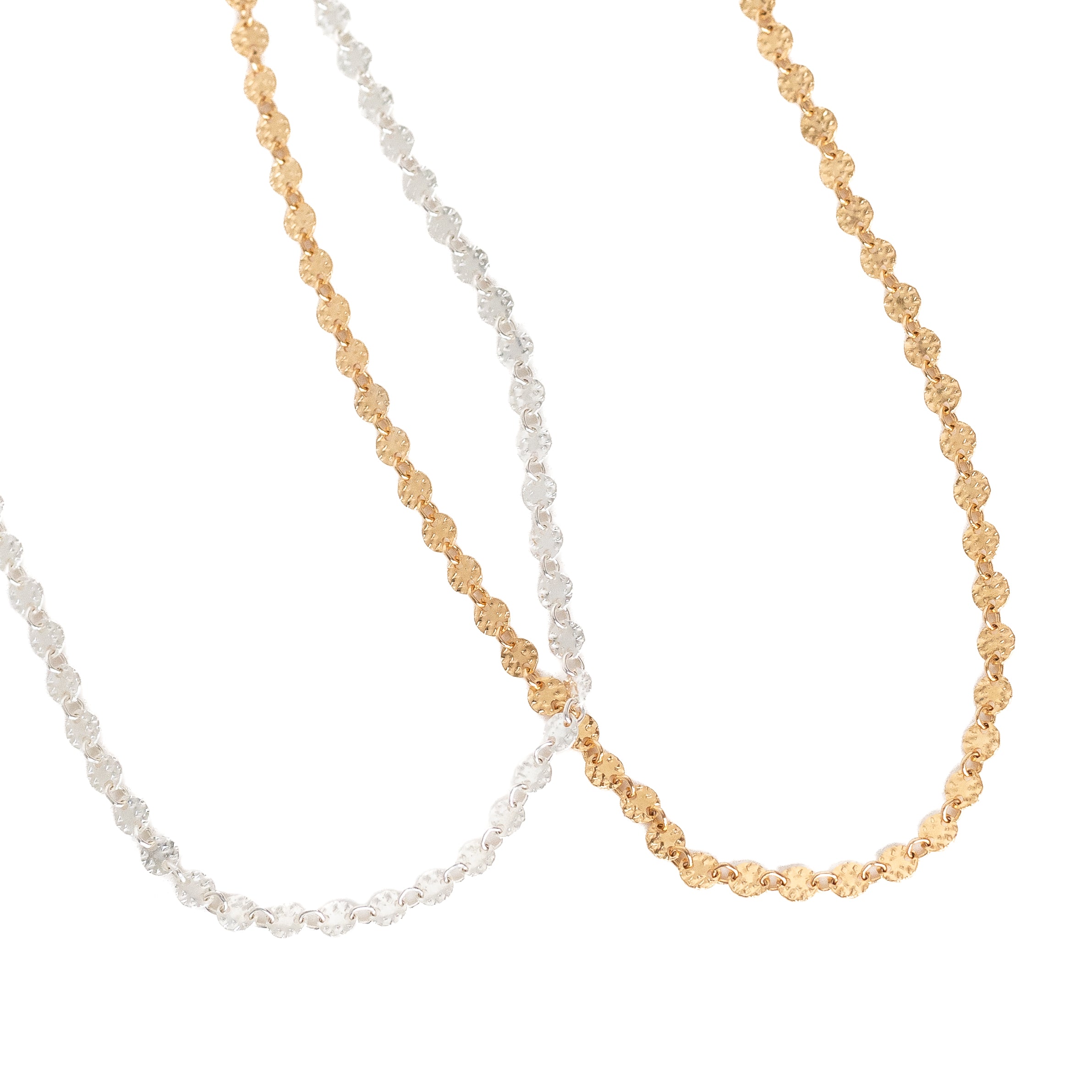 14k gold-filled chain made up of tiny textured discs. To the left of it is a sterling silver chain made up of tiny textured discs. Available in 15", 16" or 18".