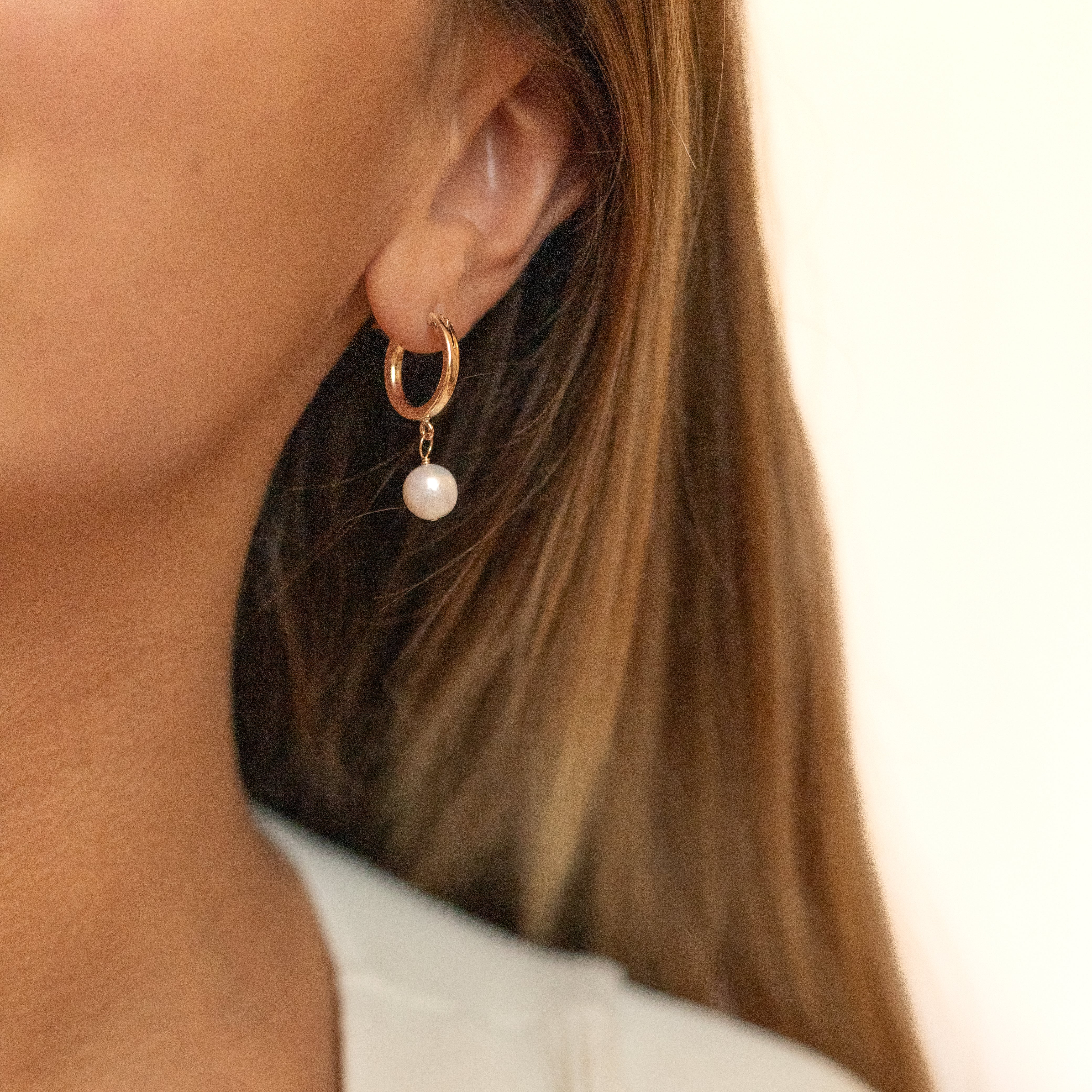 18 millimeter gold filled hoops with a tiny pearl wire wrapped to hang from the bottom. Shown in a woman's ear. 