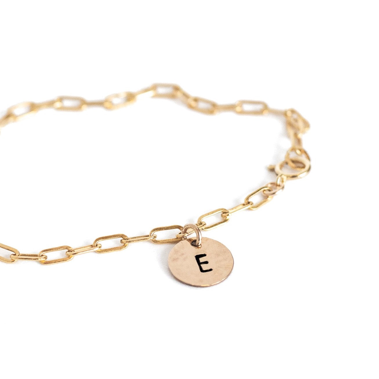Gold filled paperclip chain bracelet with a small gold filled circle charm with an E stamped on it.