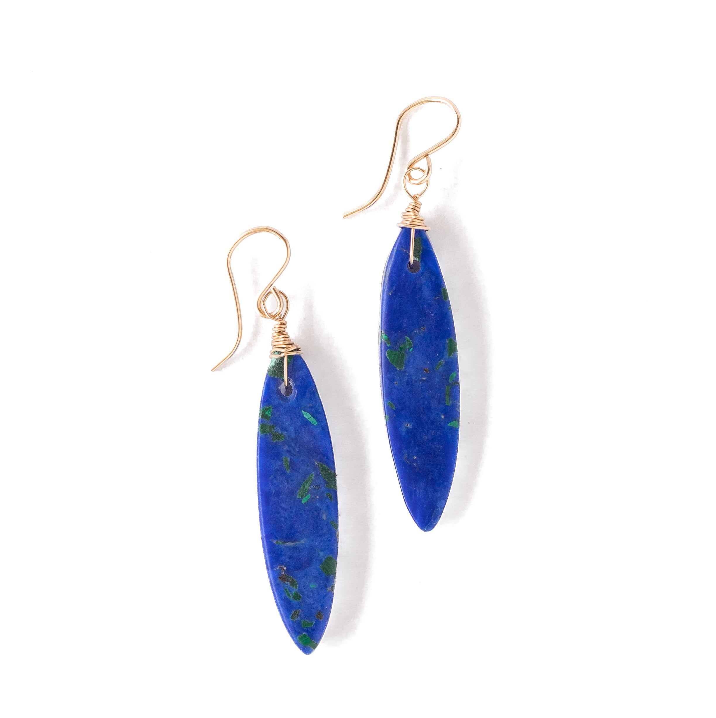 A pair of dangle earrings featuring polished blue lapis lazuli stones with natural green and gold inclusions, suspended from gold-toned French hook wires, set against a plain white background.