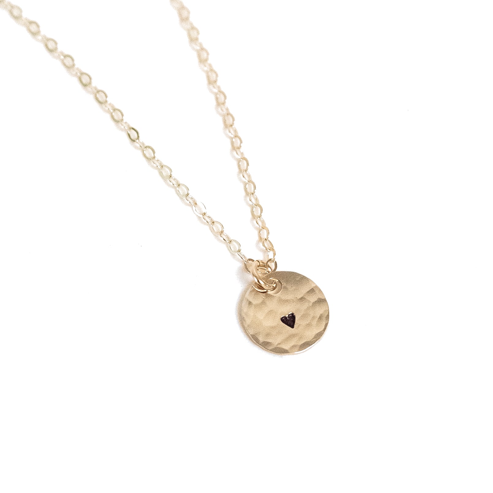 Tiny gold filled hammered circle with a tiny heart stamped on it. Shown on our dainty basic gold chain 
