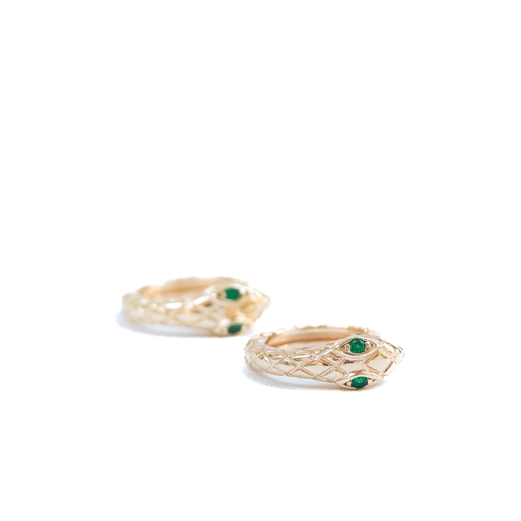 Gold plated snake huggie hoop earrings with green stones as the eyes. 