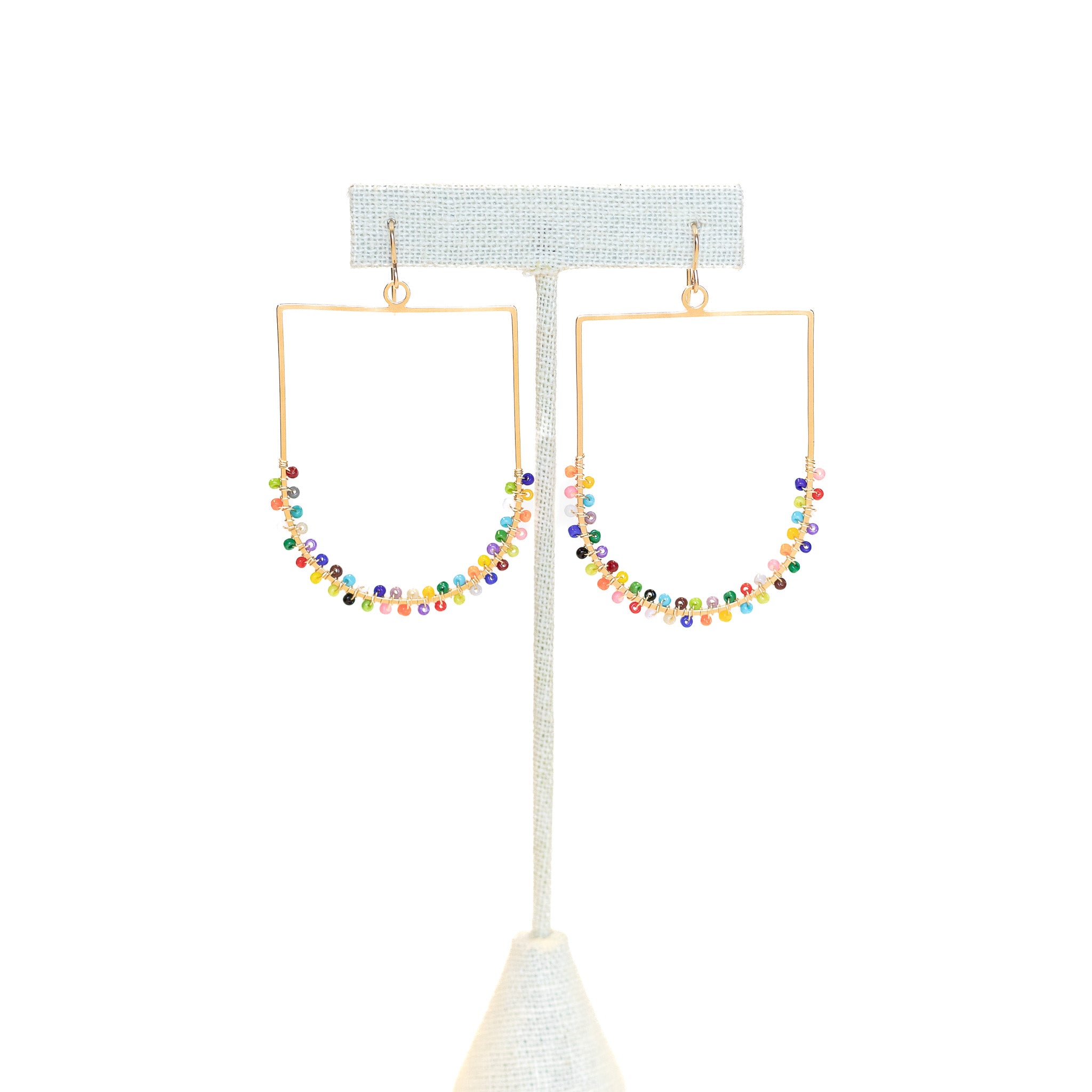 Gold rectangular earings with a curve on the bottom. Wrapped randomly with colorful beads filling the earrings halfway.