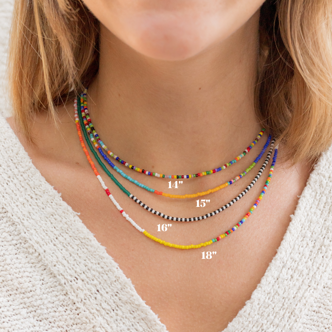 four different colorful and random seed bead necklaces on a woman's neck showing the different length options. It goes from 14 inches, 15 inches, 16 inches, and 18 inches. 
