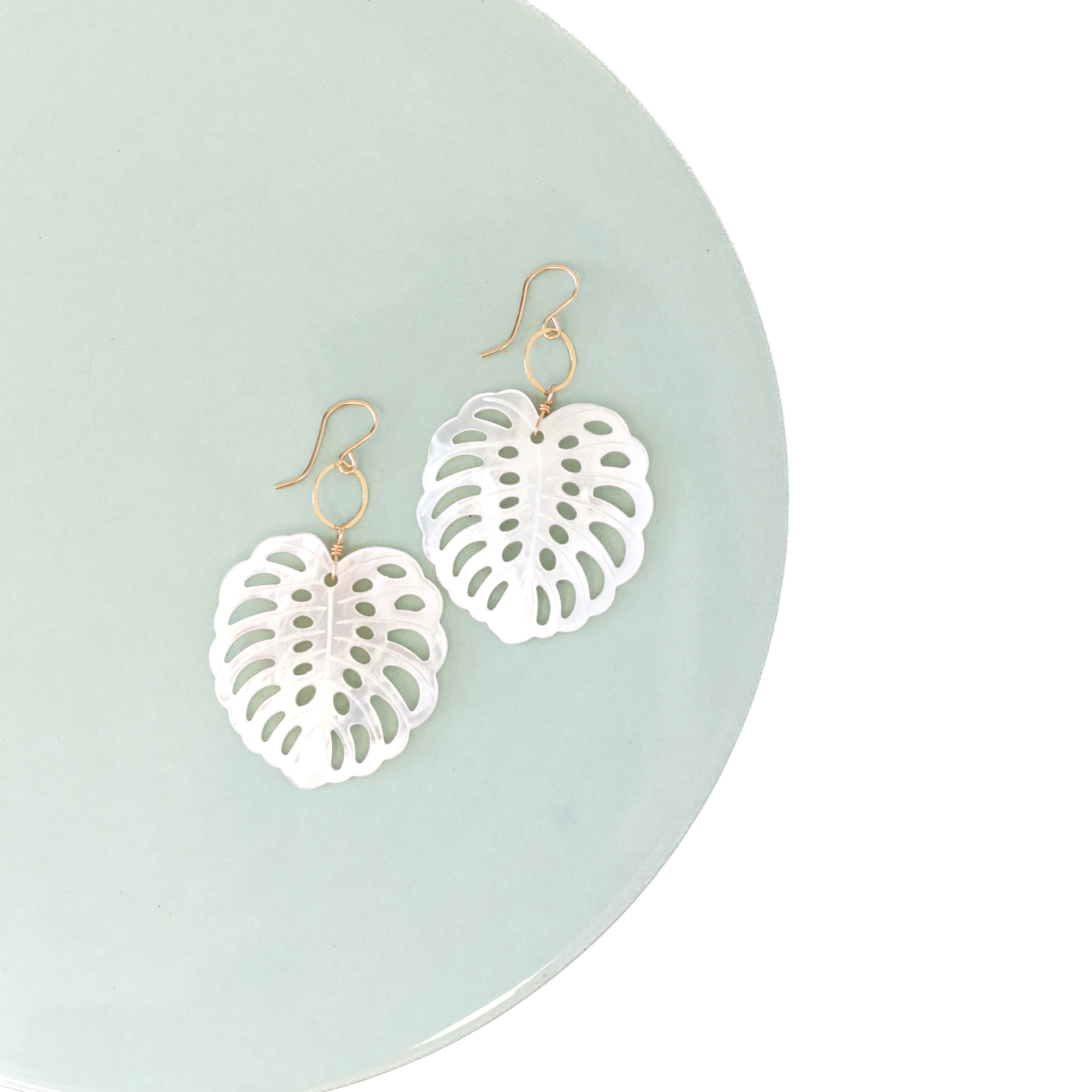 Mother of pearl monstera earrings. Attached to a small gold circle. around 2 inches in length. 
