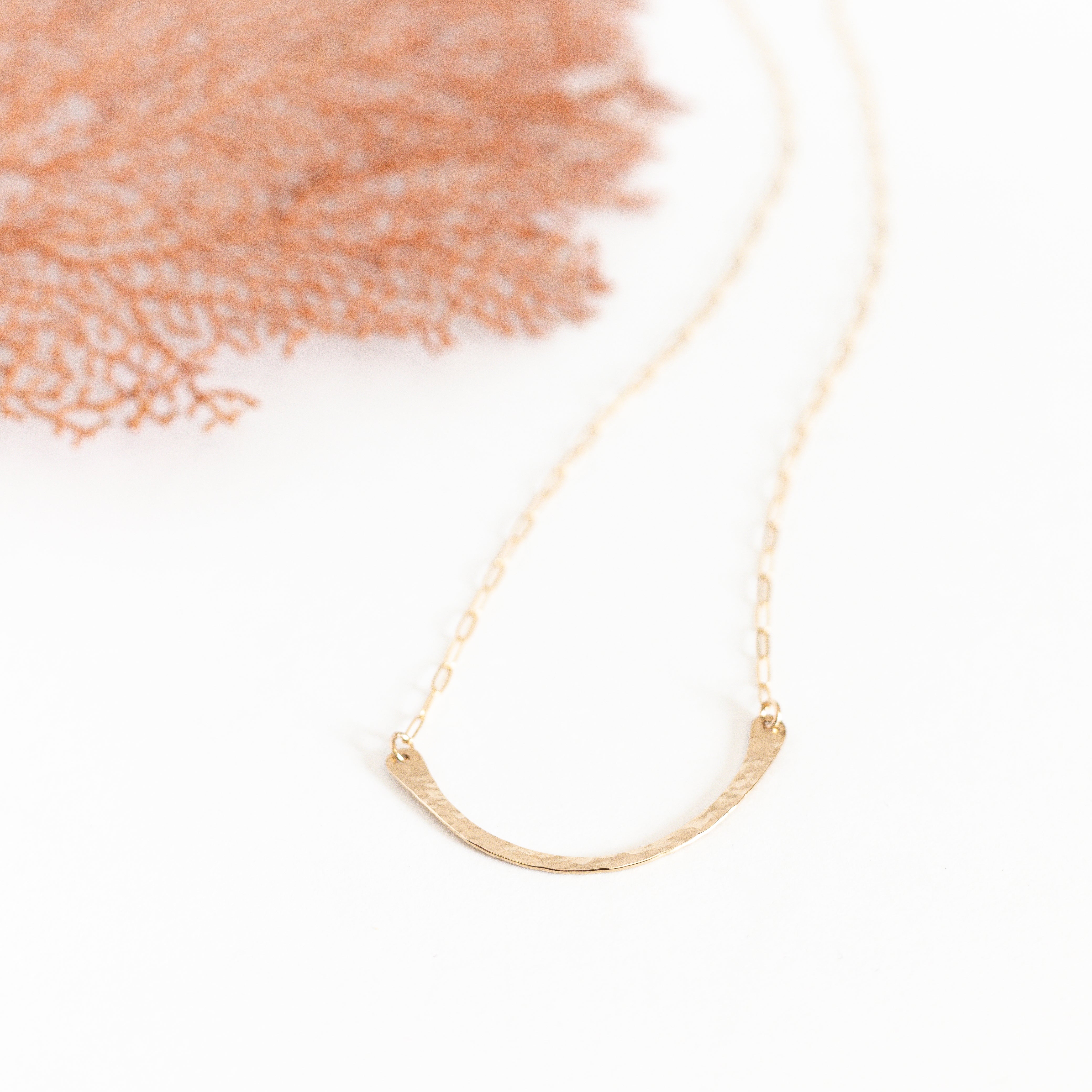 Delicate gold filled hammered bar that is curved in a U shape. attached to our thin paperclip chain.