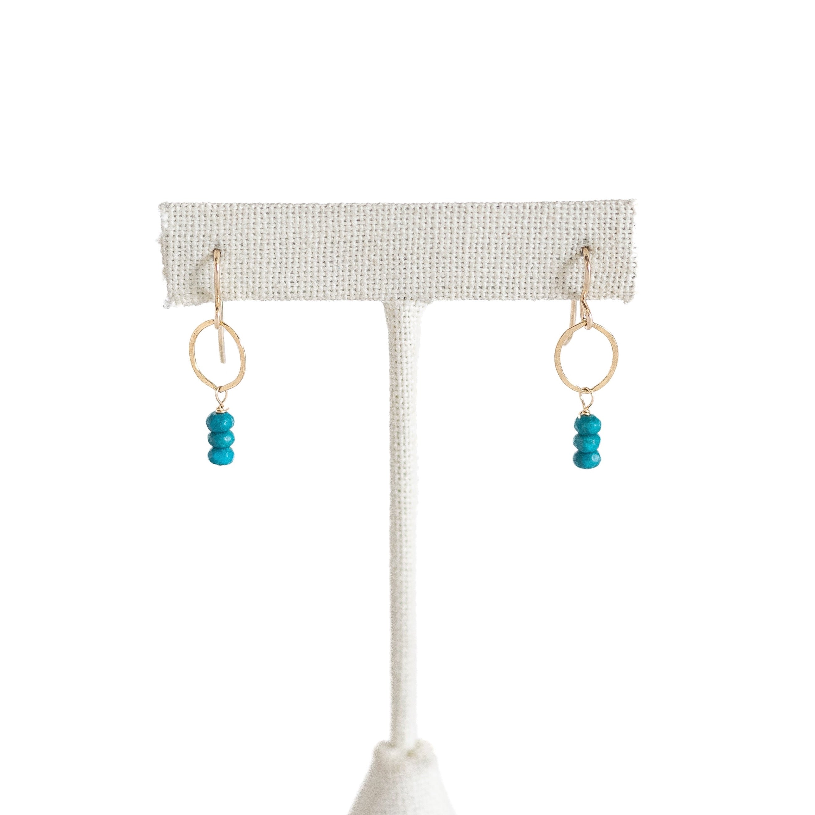 Gold filled tiny hoop with turquoise beads hanging from the bottom of the loop. 