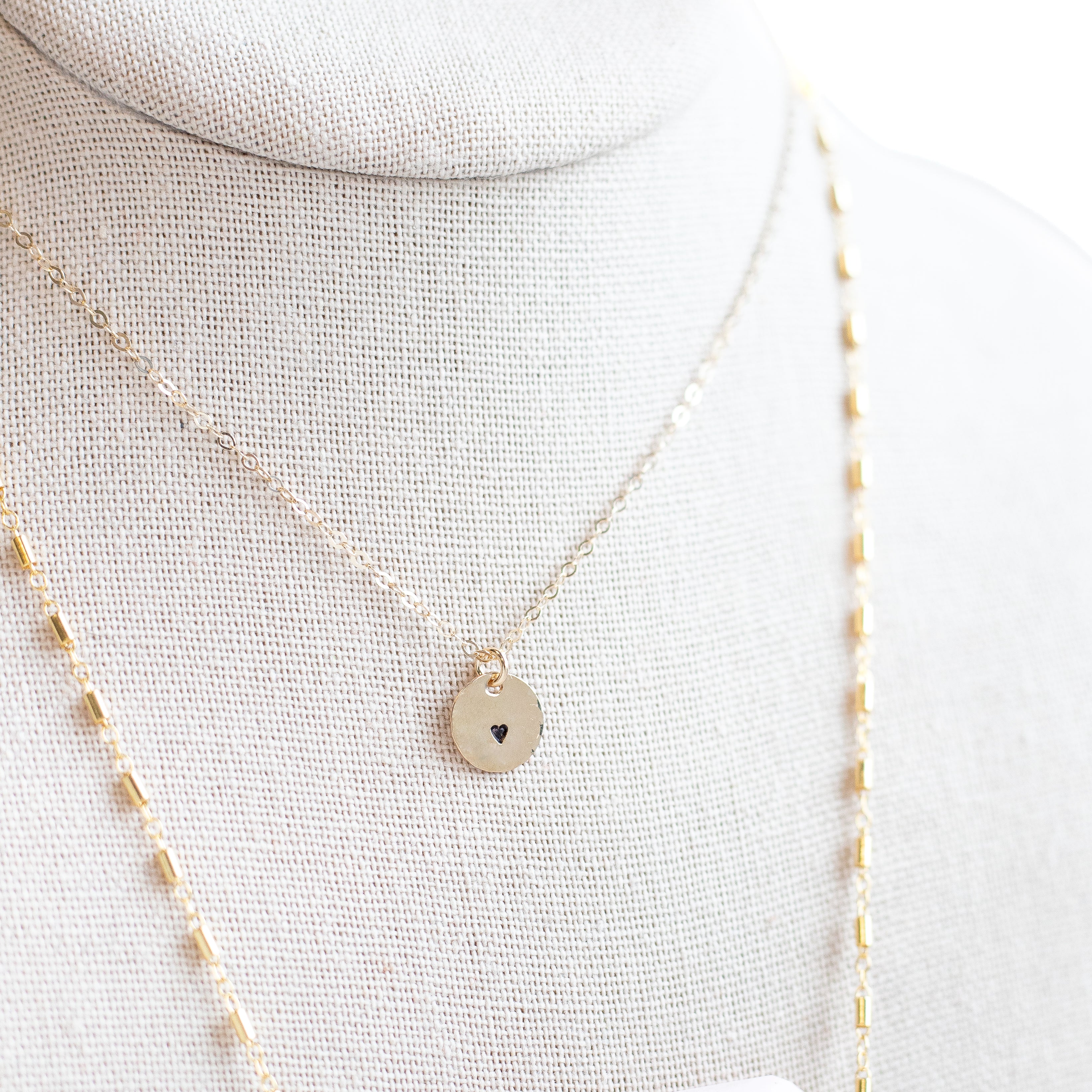 Teeny tiny circle with a heart stamped on it. on a gold filled chain. 