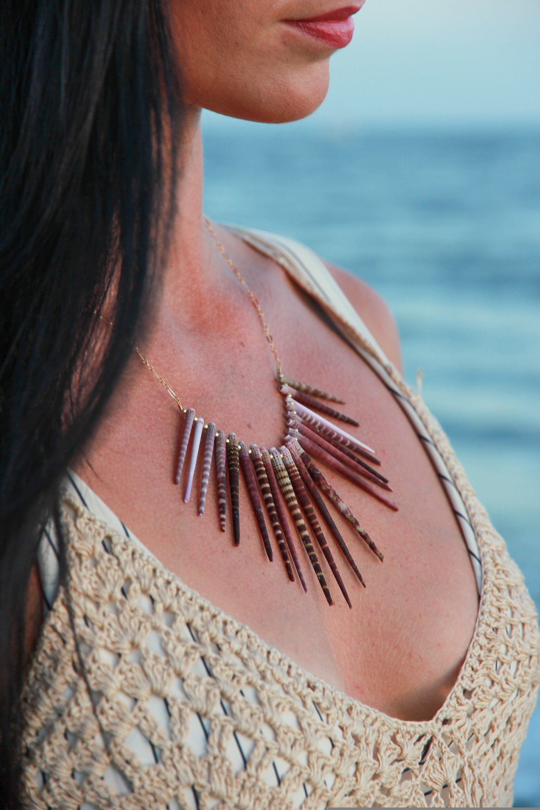 Sea urchin spine necklace shown on a woman's neck. 