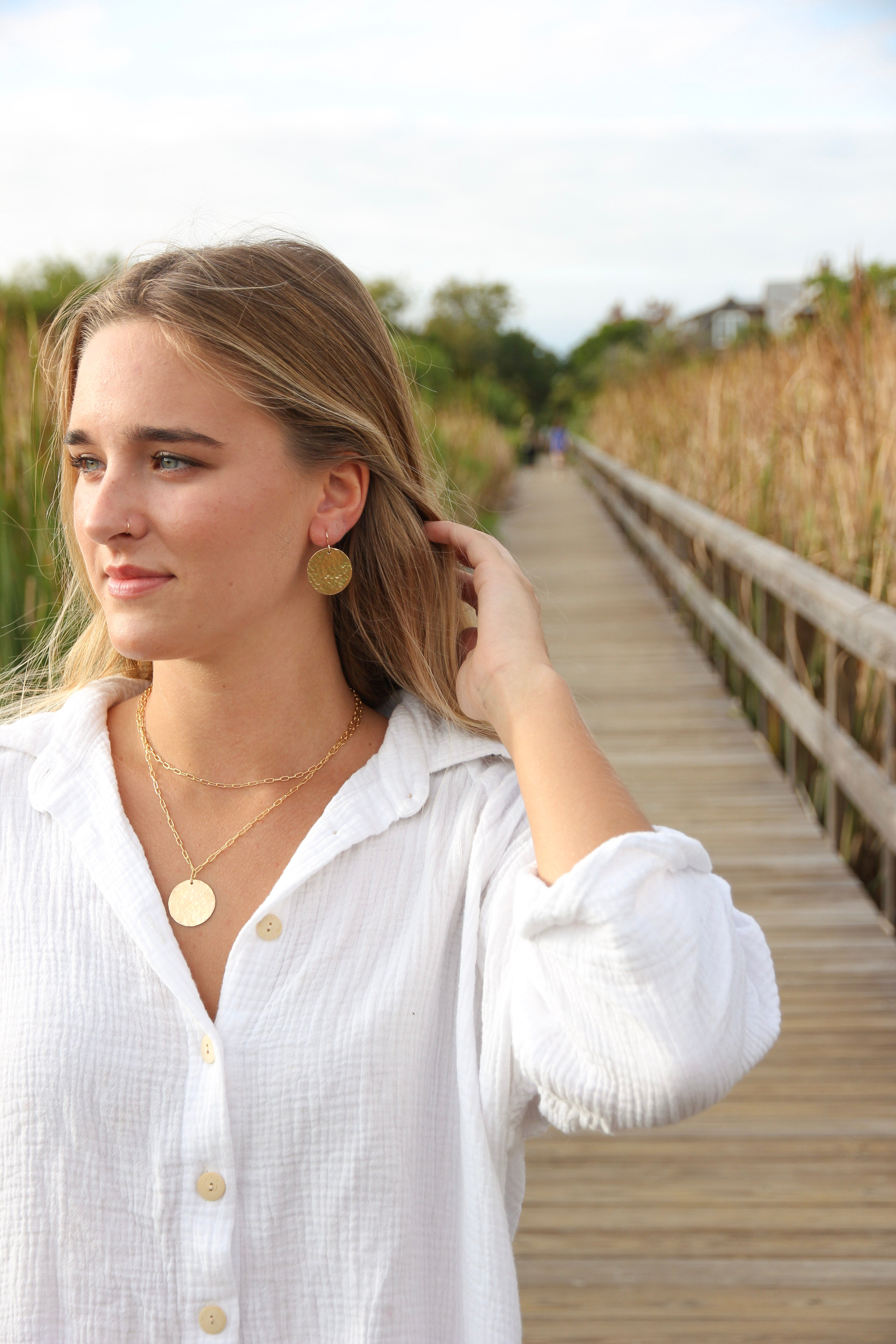 Mini paperclip choker layered with an 18 inch paperclip chain necklace with a gold filled medallion circle. Shown on a woman's neck 