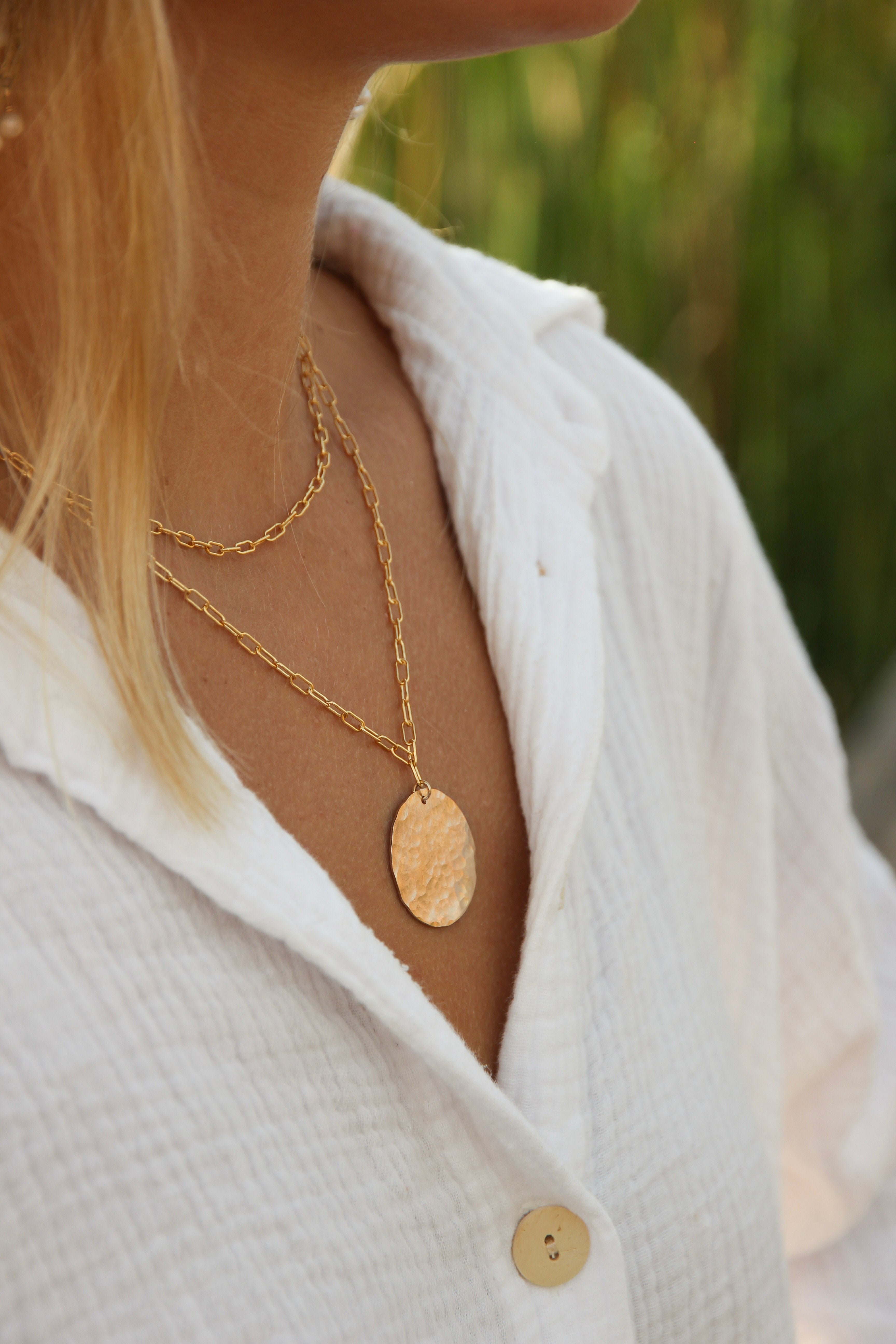 Mini paperclip choker layered with an 18 inch paperclip chain necklace with a gold filled medallion circle. Shown on a woman's neck. 