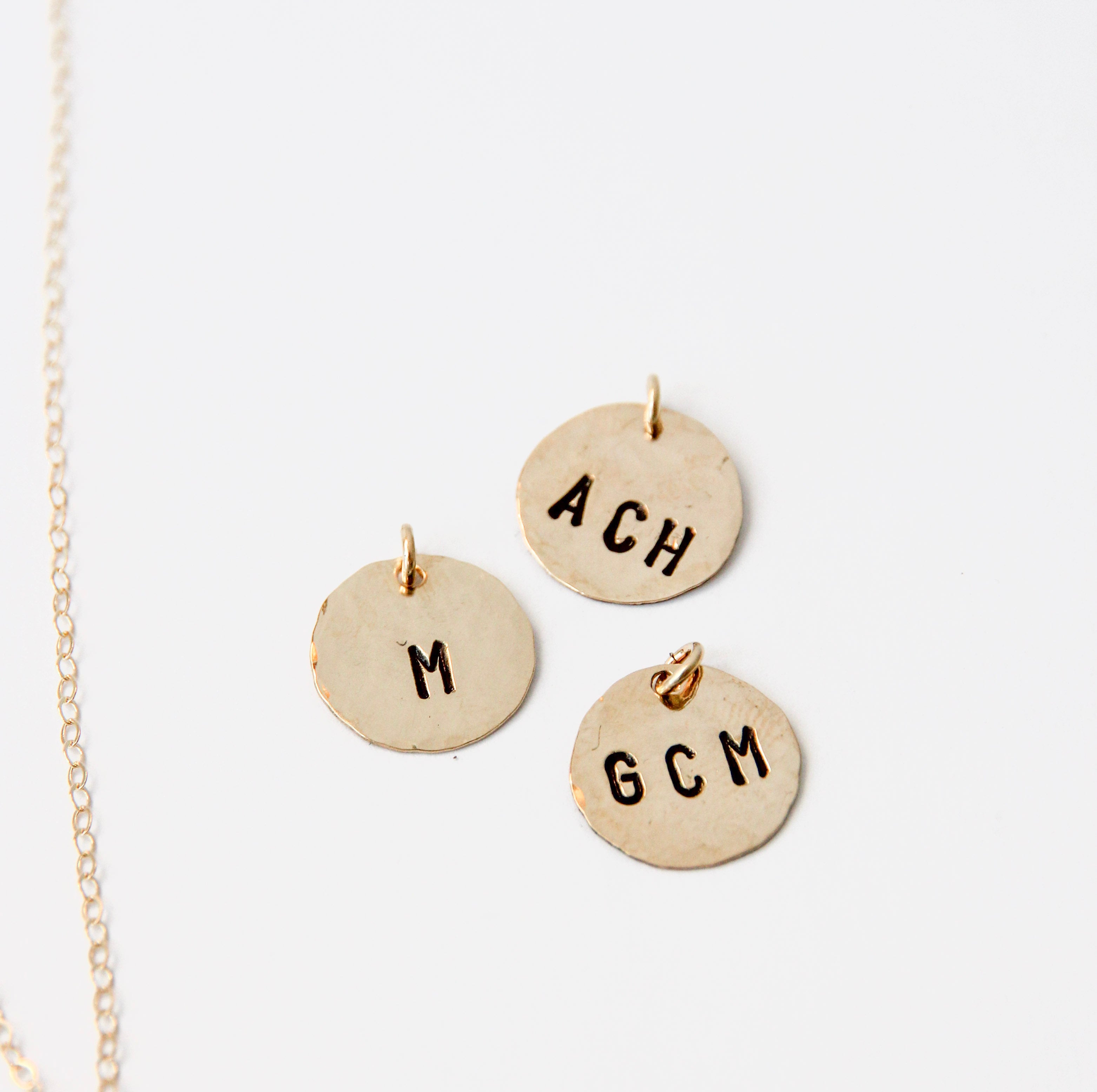 Medium size gold filled hammered circle with initials stamped onto it. Shown with three examples. 