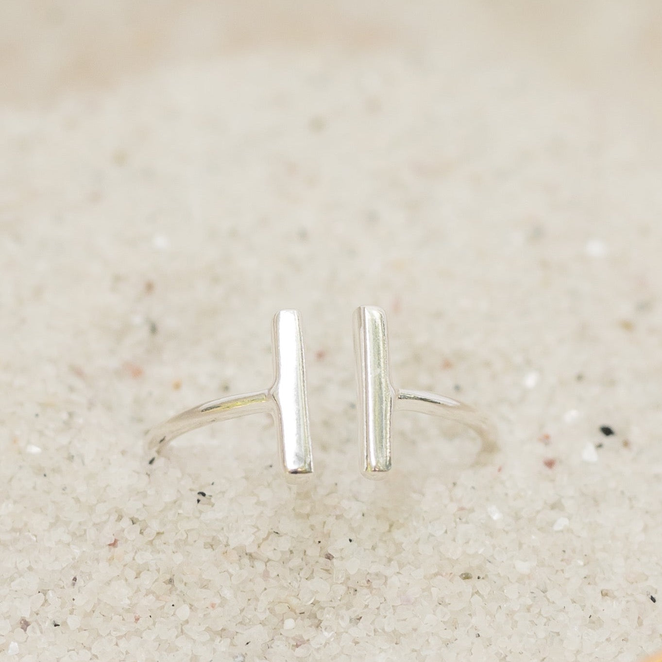 Sterling silver bar ring pictured in sand. 