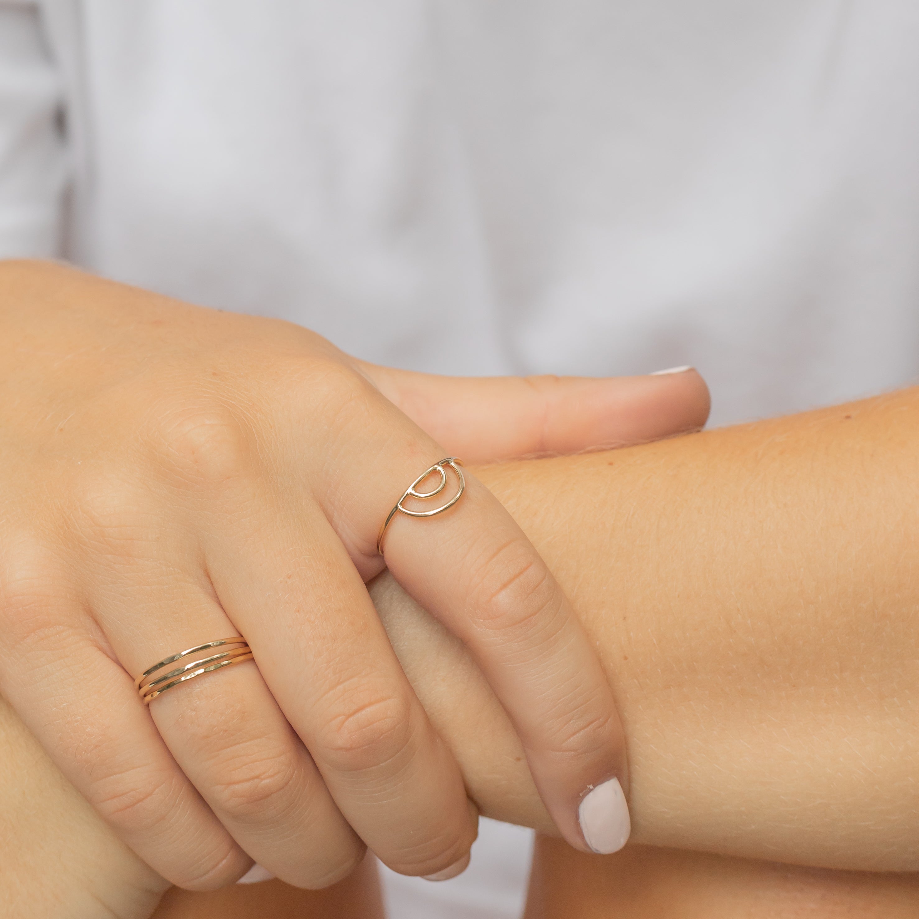 Yellow gold filled double arch rainbow ring. Shown on a woman's pointer finger. 