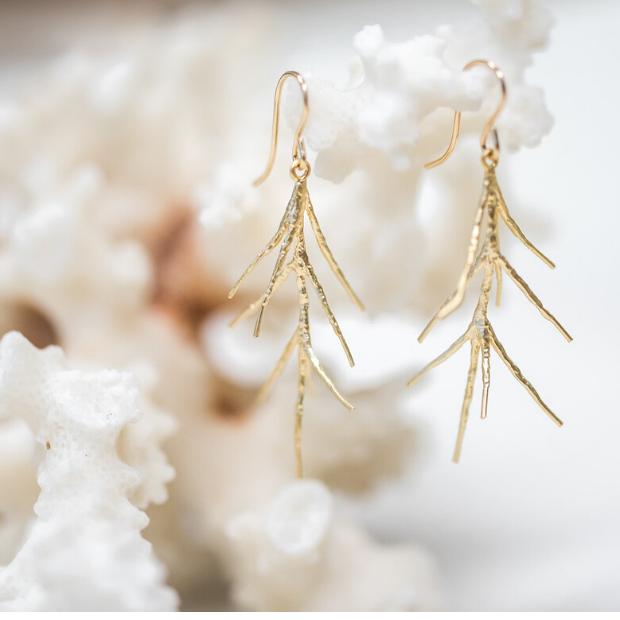 Brass twig earrings shown on a piece of coral.