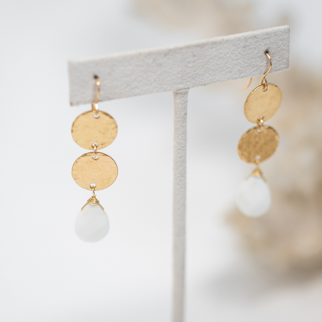 2 delicate and pretty gold hammered discs, with a faceted mother of pearl briolette hanging from the bottom. Gold filled hooks, overall length is 2 inches long.