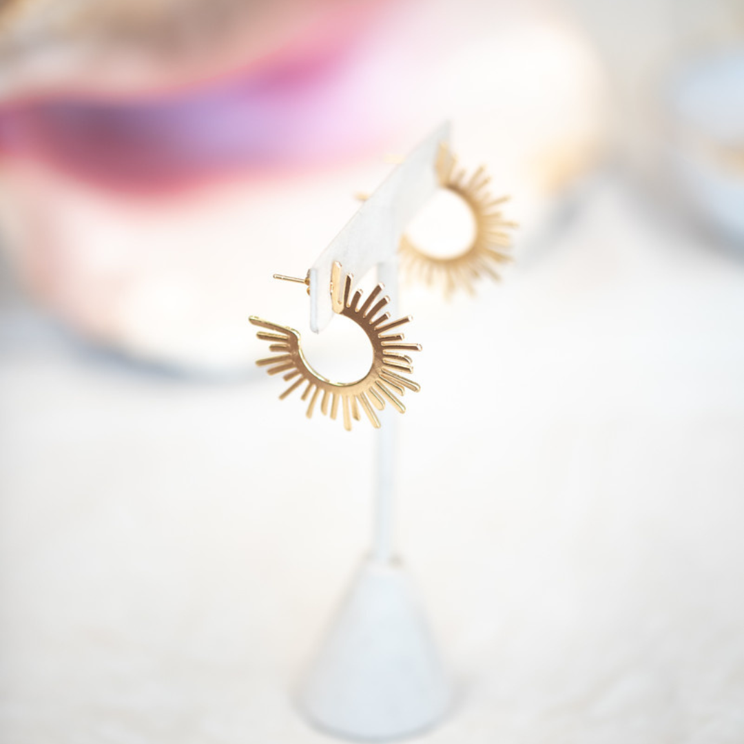 Gold plated earrings that look like a sunburst. 